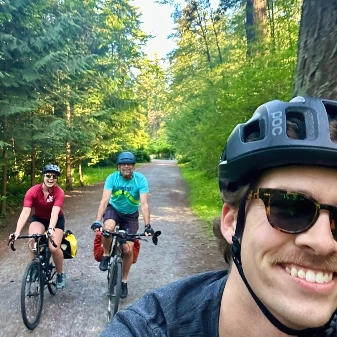 three people smiling riding bikes 