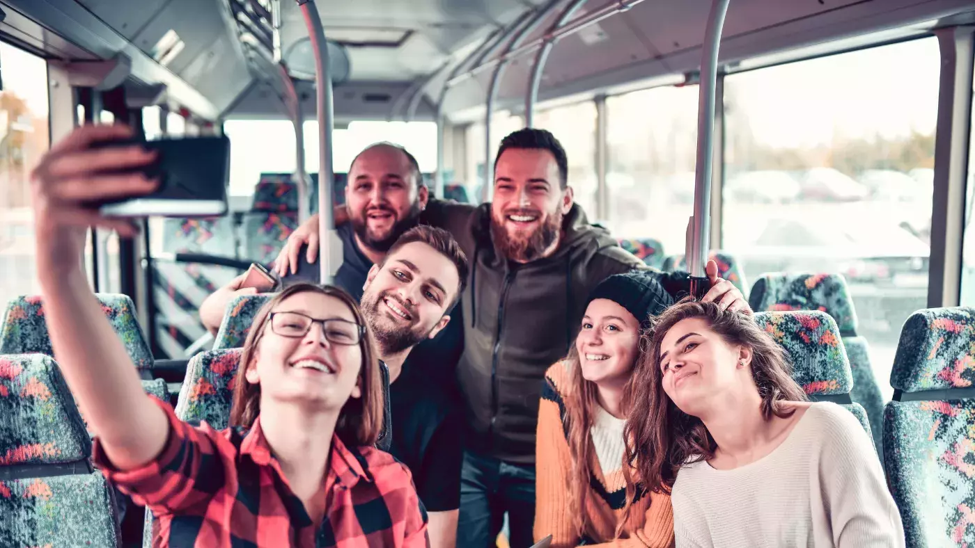 group taking a selfie on a busw 