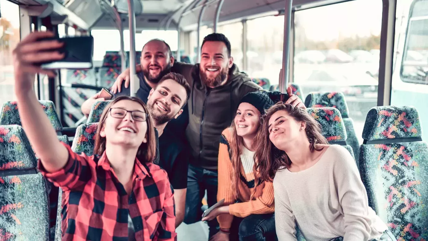 group of people taking a selfie on a bus