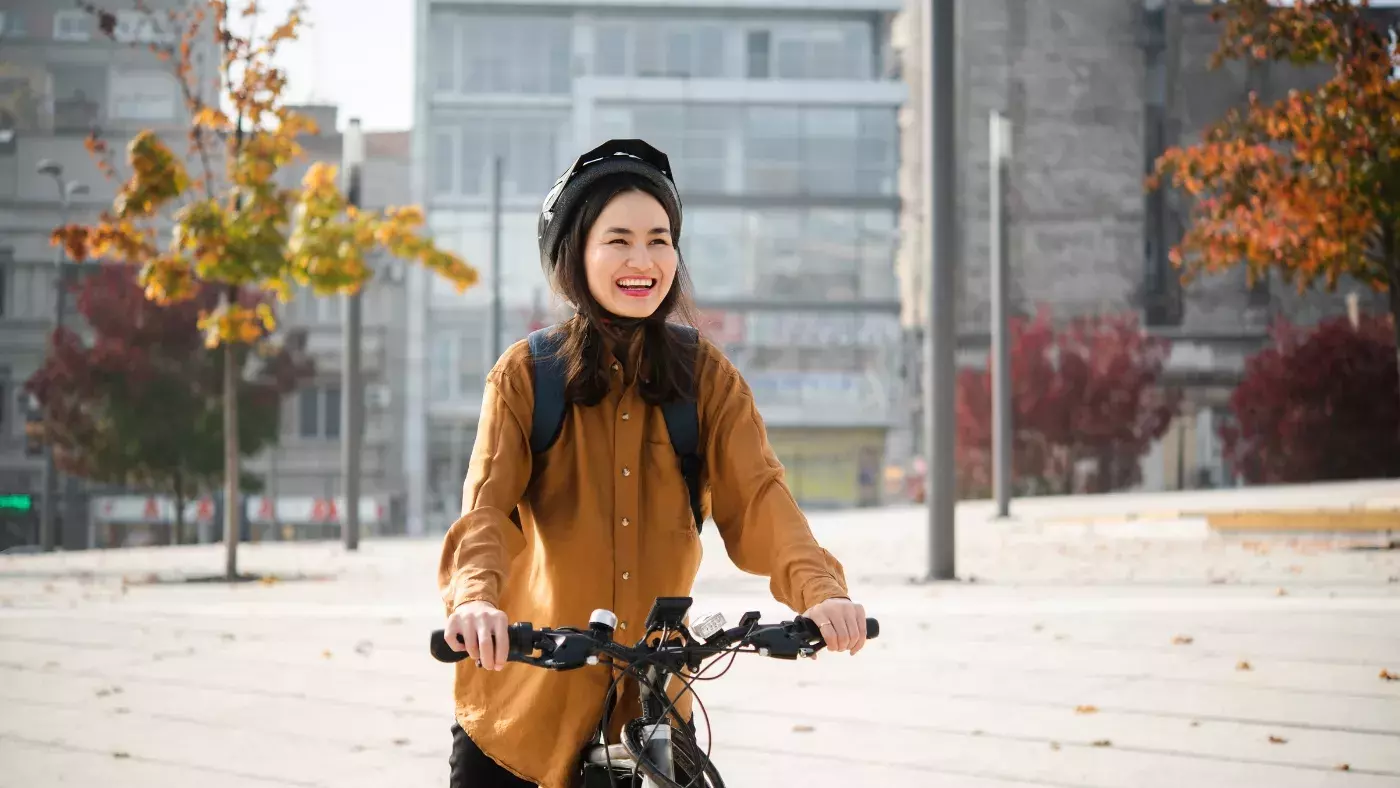 smiling women sitting on a bike wearing a helmet 