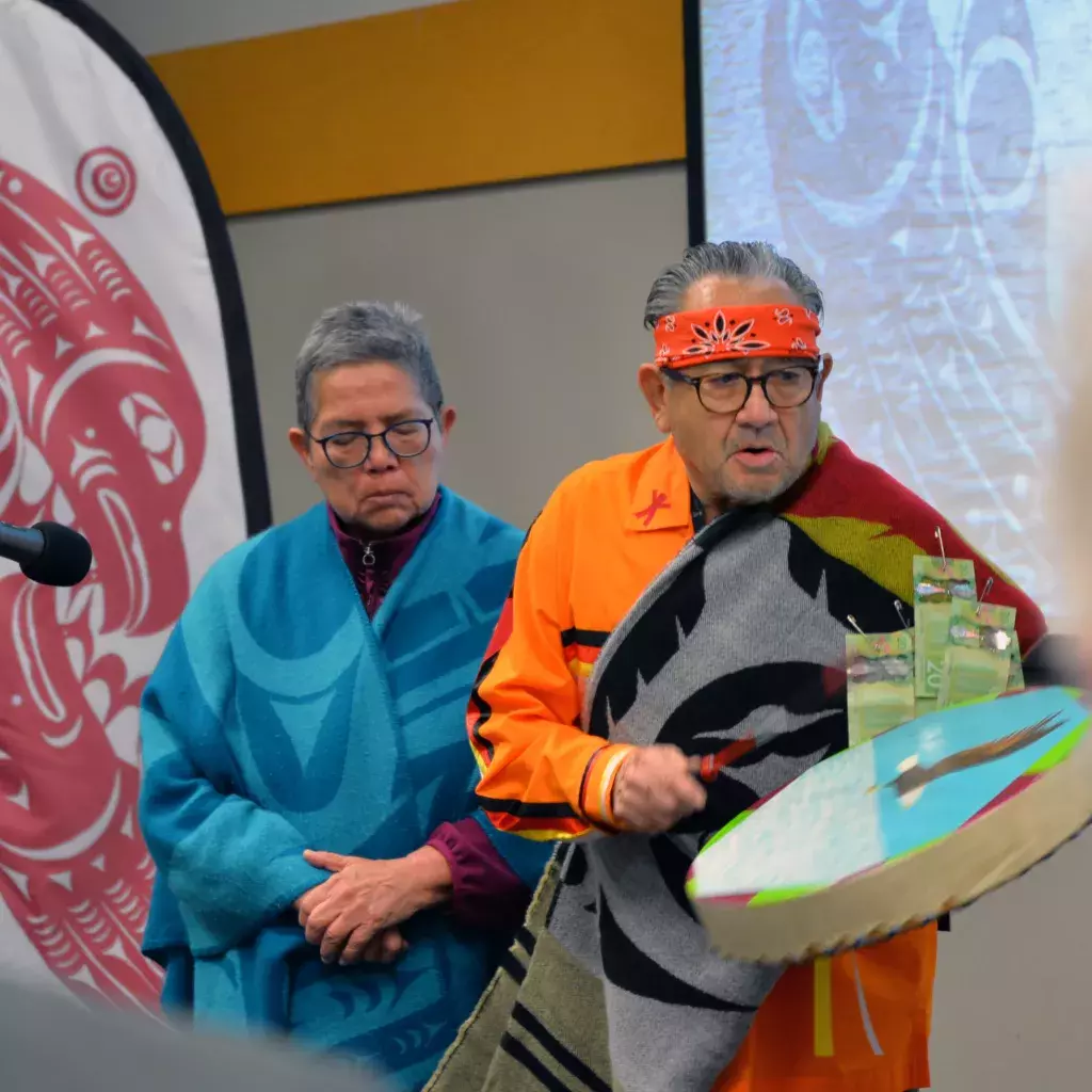 KPU Elder in Residence Lekeyten, holding a drum, stands with wife Cheryl Gabriel while offering a blessing.