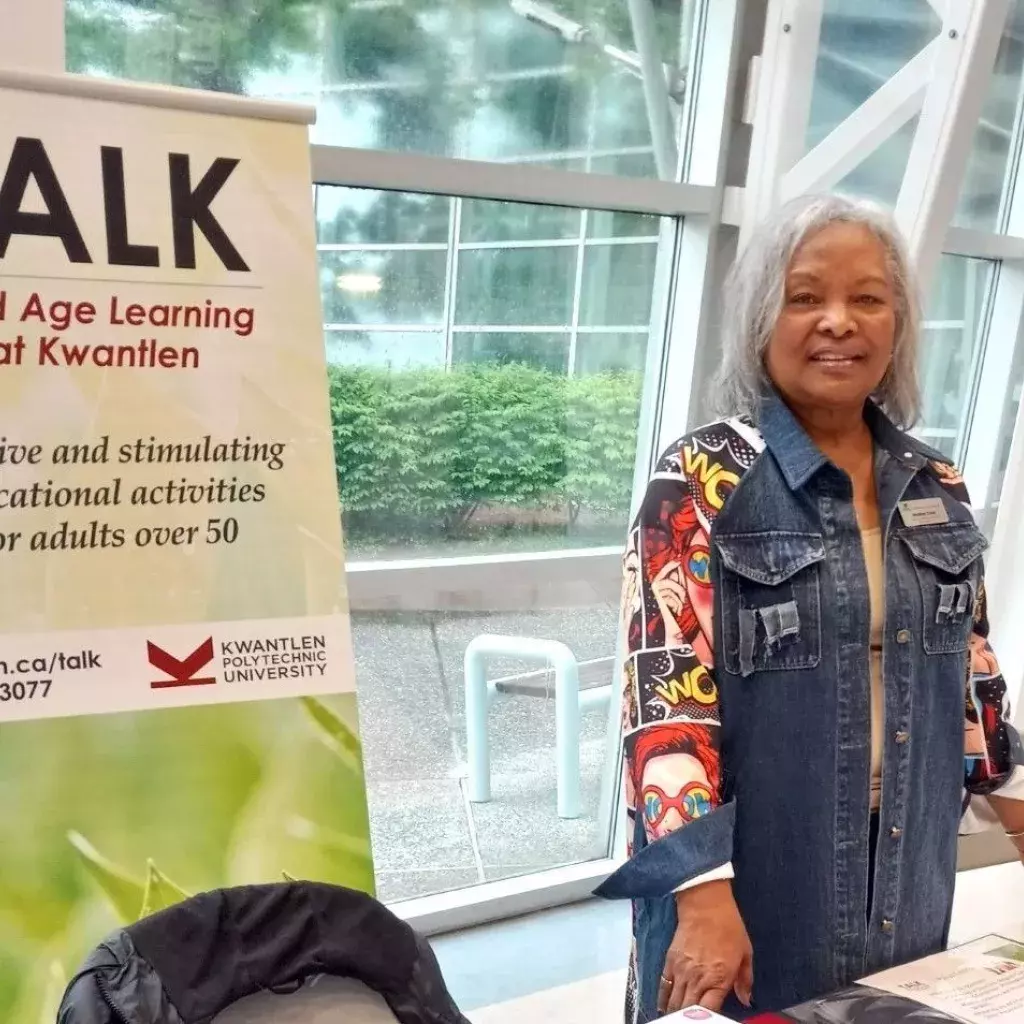 A volunteer standing at a TALK information booth.