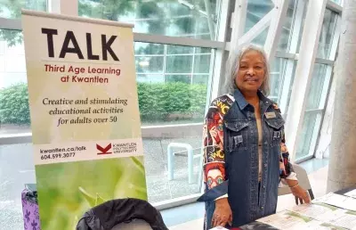 A volunteer standing at a TALK information booth.